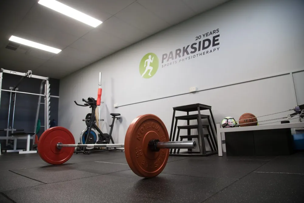 Rehab gym with barbell, plyo boxes and bike